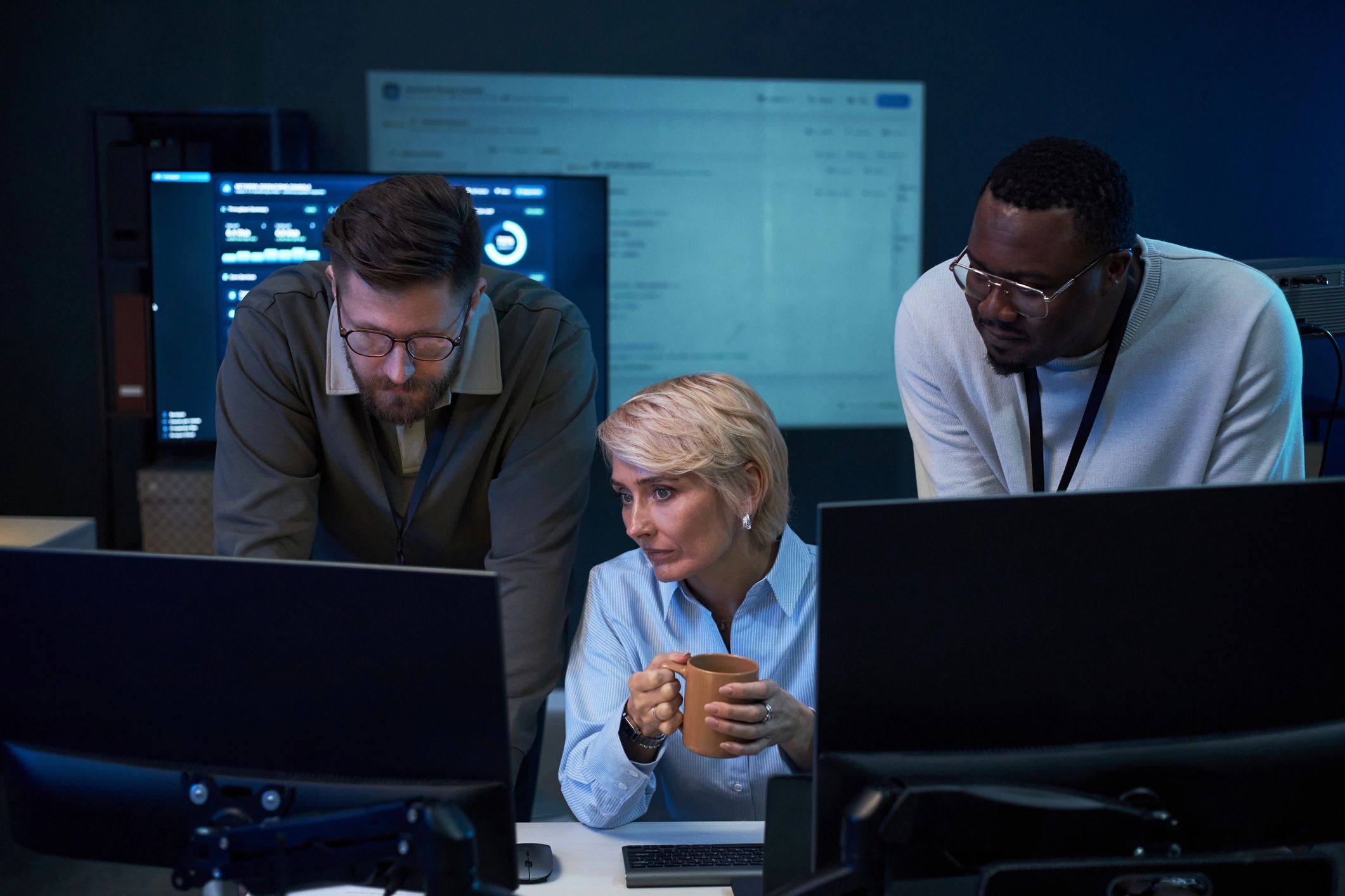 Security analysts monitoring data on large screens